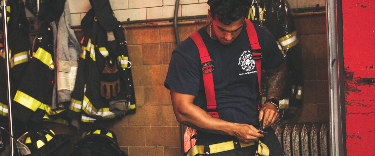 Firefighter getting equipment put on.