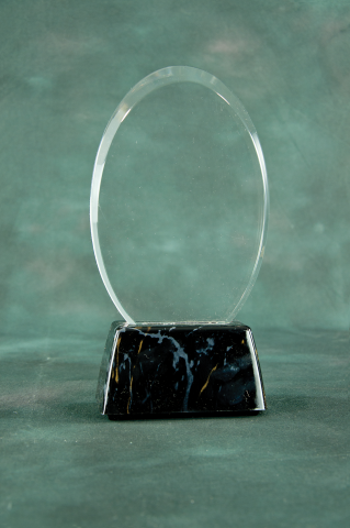 Oval shaped acrylic mounted on a black marble finished base.